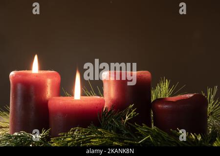 Couronne de l'Avent avec bougies rouges et deux bougies allumées pour la deuxième semaine de l'Avent avec des creux à feuilles persistantes et un espace de copie Banque D'Images