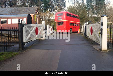 Autobus à impériale d'époque Routemaster sur le passage à niveau à la gare Staverton du South Devon Railway. Banque D'Images