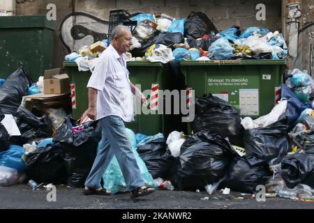 Un homme pases devant les ordures dans le centre d'Athènes sur 23 juin 2017. Des piles de déchets s'accumulent autour des poubelles débordant d'Athènes, à la suite de grèves répétées appelées par la Fédération des travailleurs dans les municipalités exigeant l'embauche permanente d'environ 10 000 travailleurs contractuels dont les contrats ont expiré (photo de Panayotis Tzamaros/NurPhoto) *** Veuillez utiliser le crédit du champ de crédit *** Banque D'Images