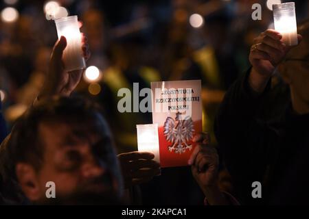 Une personne tient une copie de la « Constitution polonaise » lors d'une veillée aux chandelles anti-gouvernement devant le tribunal de district de Cracovie mercredi soir où des centaines de personnes se sont rassemblées pour la dixième nuit consécutive en relation avec des réformes judiciaires. Mercredi, 26 juillet 2017, à Cracovie, en Pologne. Photo par Artur Widak *** Veuillez utiliser le crédit du champ de crédit *** Banque D'Images
