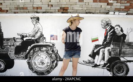 Agnes Cieslinska, étudiante polonaise, pose à côté de la fresque murale représentant le président américain Donald Trump, dans le cadre du nouveau Festival mural dans le village de Staro Zhelezare, Bulgarie, mercredi 26 juillet 2017. Les peintures murales extérieures sur les murs des maisons du village de Staro Zhelezare présentent des gens locaux ainsi que des figures bien connues des mondes de la politique et de la religion. (Photo de Valentina Petrova/NurPhoto) *** Veuillez utiliser le crédit du champ de crédit *** Banque D'Images