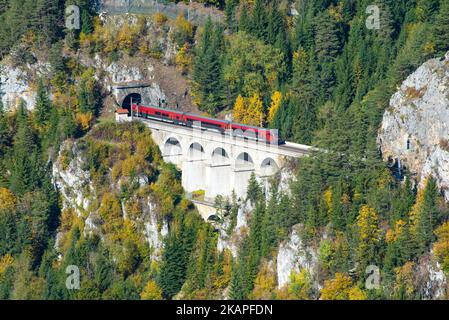 Train rouge sur un viaduc entre deux tunnels du chemin de fer Semmering. Le chemin de fer Semmering est le plus ancien chemin de fer de montagne d'Europe et un monde de l'UNESCO Banque D'Images