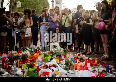 Les gens se trouvent à côté de bougies et de fleurs à Las Ramblas de Barcelone, Espagne, le 18 août 2017, pour rendre hommage aux victimes un jour après qu'une camionnette a labouré dans la foule, tuant 14 personnes et blessant plus de 100 personnes. (Photo de Jordi Boixareu/NurPhoto) Banque D'Images