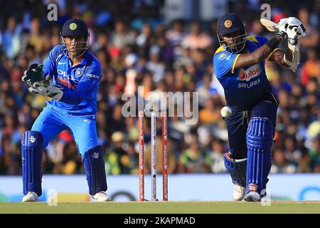 Le cricketer sri lankais Angelo Mathews (R) joue un coup de feu alors que le MS indien Dhoni regarde pendant le match international de cricket d'une journée 1st entre le Sri Lanka et l'Inde au stade de cricket international de Dambulla situé dans la province centrale et le premier et unique terrain de cricket international dans la zone sèche Du Sri Lanka le dimanche 20 août 2017. (Photo de Thharaka Basnayaka/NurPhoto) Banque D'Images