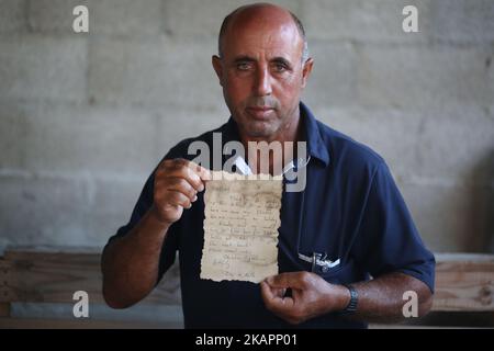 Le pêcheur palestinien Jihad al-Soltan affiche un message écrit par Bethany Wright et son petit ami Zac Marriner, après qu'il l'a trouvé dans une bouteille au large d'une plage de Gaza, à Gaza-21 août 2017. Le pêcheur de Gaza dit qu'il a contacté Bethany et Zac à Greech qui a exprimé le plaisir de leur message reacha Gaza et ils passent leur régarda au peuple palestinien. Bethany et Zac ont été contactés par des joutnalistes pour trouver l'origine de ce message dans une bouteille histoire. Ils lui ont envoyé des photos d'eux par e-mail. Ils ont dit qu'ils étaient heureux de leur message à Gaza. (Photo de Majdi Fathi/NurPhoto) Banque D'Images