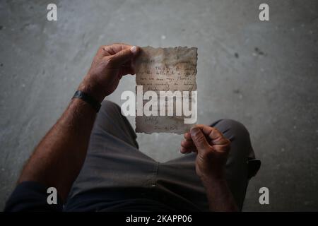 Le pêcheur palestinien Jihad al-Soltan affiche un message écrit par Bethany Wright et son petit ami Zac Marriner, après qu'il l'a trouvé dans une bouteille au large d'une plage de Gaza, à Gaza-21 août 2017. Le pêcheur de Gaza dit qu'il a contacté Bethany et Zac à Greech qui a exprimé le plaisir de leur message reacha Gaza et ils passent leur régarda au peuple palestinien. Bethany et Zac ont été contactés par des joutnalistes pour trouver l'origine de ce message dans une bouteille histoire. Ils lui ont envoyé des photos d'eux par e-mail. Ils ont dit qu'ils étaient heureux de leur message à Gaza. (Photo de Majdi Fathi/NurPhoto) Banque D'Images