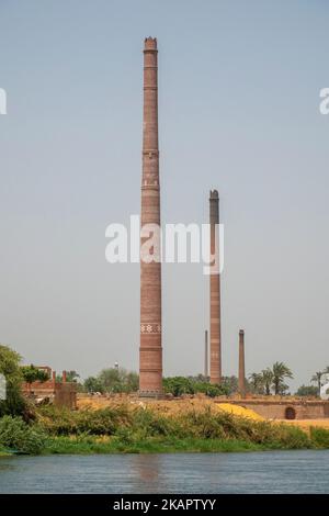 Cheminées industrielles faites de briques rouges à motifs sur les rives du Nil, en Égypte Banque D'Images