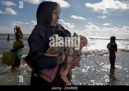 Une mère de Rohingya pleure, tenant son enfant de deux mois et se promène sur la rive après avoir traversé la rivière NAF en bateau. Shahpirer DIP, Teknaf, Bangladesh ; 14 septembre 2017. Le Bangladesh utilisera des troupes pour fournir une aide étrangère à la ville frontalière submergée par les réfugiés musulmans Rohingya du Myanmar, ont annoncé à la fin du 14 septembre. Cette décision fait suite à la critique des conditions chaotiques dans lesquelles les secours ont été distribués dans les immenses camps autour de Cox's Bazar, où environ 389 000 Rohingya de l'État Rakhine du Myanmar sont arrivés depuis 25 août. (Photo de Turjoy Chowdh Banque D'Images