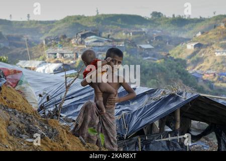 Un garçon de Rohingya avec son frère se tient près de sa tente de fortune au camp de Balukhali à Ukhiya, au Bangladesh, le 15 septembre 2017. Bon nombre des Rohingya fuyant les violences au Myanmar avaient voyagé en bateau pour trouver refuge au Bangladesh voisin. Selon les Nations Unies, plus de 300 000 réfugiés Rohingya ont fui la violence au Myanmar au cours des dernières semaines, essayant pour la plupart de traverser la frontière et d'atteindre le Bangladesh. (Photo de KM Astad/NurPhoto) Banque D'Images