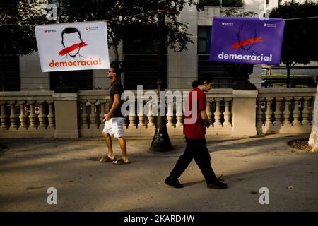 Deux hommes marchent devant des bannières lisant « démocratie » devant le bâtiment de la haute Cour catalane à Barcelone, Espagne, le 22 septembre 2017. Des manifestations contre l'arrestation de 14 responsables catalans par les forces de sécurité espagnoles ont lieu depuis hier dans le bâtiment de la haute Cour catalane. Le gouvernement catalan entend célébrer un référendum sur l’indépendance le 1er octobre prochain, le gouvernement espagnol est frontalement opposé au référendum et le considère illégal. (Photo de Jordi Boixareu/NurPhoto) Banque D'Images