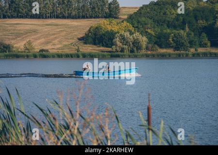 Deux fyshemen en bateau à moteur voilent des vagues de dissection sur l'eau de la rivière Banque D'Images