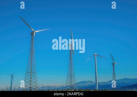Ferme de moulin à vent dans un désert avec des tours tubulaires en acier et en treillis contre la montagne en Californie. Éoliennes contre la vue de la chaîne de montagnes a Banque D'Images