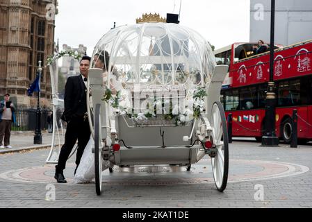 Un couple chinois a des photos avant mariage prises en calèche Cendrillon à l'extérieur du Parlement de Londres sur 20 octobre 2017. Londres est de plus en plus populaire en tant que lieu de photographie avant mariage grâce en partie à ses monuments immédiatement reconnaissables. (Photo par Alberto Pezzali/NurPhoto) Banque D'Images