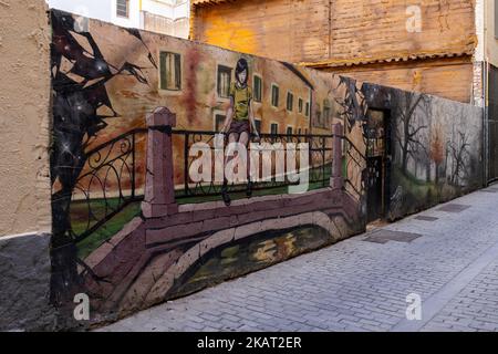 Illustration de la jeune fille assise sur la clôture sur le pont sur le mur, Carrer de Moret, Valence, Espagne Banque D'Images