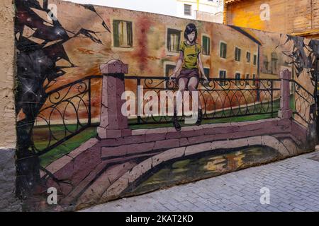 Illustration de la jeune fille assise sur la clôture sur le pont sur le mur, Carrer de Moret, Valence, Espagne Banque D'Images