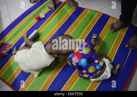 Les filles jumelles Rabeya Islam et Rokeya Islam jouent dans un hôpital de Collage médical de Dhaka, au Bangladesh, sur 21 novembre 2017. Taslima Khatun, professeur d'école, a donné naissance aux jumeaux à tête conjointe le 16 juillet 2016 après une césarienne. Les jumeaux ont été admis à un hôpital médical de Dhaka pour examen avant une éventuelle chirurgie pour séparer leurs têtes. (Photo par Mamunur Rashid/NurPhoto) Banque D'Images