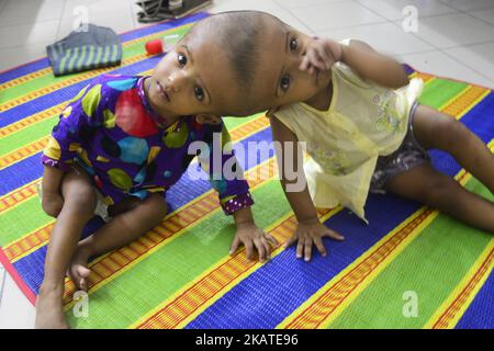 Les filles jumelles Rabeya Islam et Rokeya Islam jouent dans un hôpital de Collage médical de Dhaka, au Bangladesh, sur 21 novembre 2017. Taslima Khatun, professeur d'école, a donné naissance aux jumeaux à tête conjointe le 16 juillet 2016 après une césarienne. Les jumeaux ont été admis à un hôpital médical de Dhaka pour examen avant une éventuelle chirurgie pour séparer leurs têtes. (Photo par Mamunur Rashid/NurPhoto) Banque D'Images