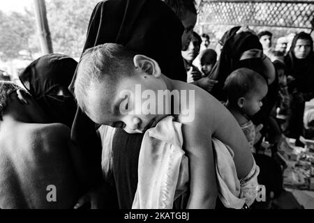 La réfugiée de Rohingya tient son jeune enfant en attente d'une aide médicale dans une clinique de terrain par l'organisation non gouvernementale Mercy Malaysia au camp de réfugiés de Thankhali près de Cox's Bazar, Bangladesh, 24 novembre 2017. (Photo de Szymon Barylski/NurPhoto) Banque D'Images