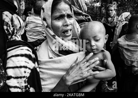 La réfugiée de Rohingya tient son jeune enfant en attente d'une aide médicale dans une clinique de terrain par l'organisation non gouvernementale Mercy Malaysia au camp de réfugiés de Thankhali près de Cox's Bazar, Bangladesh, 24 novembre 2017. (Photo de Szymon Barylski/NurPhoto) Banque D'Images