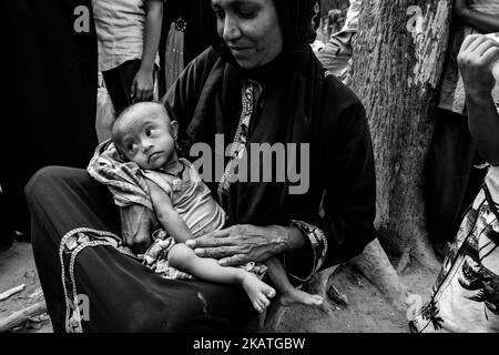 La réfugiée de Rohingya tient son jeune enfant en attente d'une aide médicale dans une clinique de terrain par l'organisation non gouvernementale Mercy Malaysia au camp de réfugiés de Thankhali près de Cox's Bazar, Bangladesh, 24 novembre 2017. (Photo de Szymon Barylski/NurPhoto) Banque D'Images