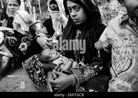 La réfugiée de Rohingya tient son jeune enfant et attend une aide médicale dans une clinique de terrain par l'organisation non gouvernementale Mercy Malaysia au camp de réfugiés de Thankhali près de Cox's Bazar, Bangladesh, 25 novembre 2017. (Photo de Szymon Barylski/NurPhoto) Banque D'Images