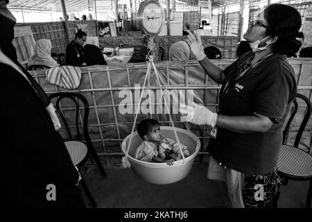 Le garçon réfugié Rohingya est pesé au centre de la prise en charge des enfants souffrant de malnutrition aiguë sévère (SAM) au camp de réfugiés de Balukhali près de Cox's Bazar, au Bangladesh, au 28 novembre 2017. (Photo de Szymon Barylski/NurPhoto) Banque D'Images