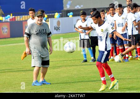 Diego Maradona, légende Argentine du football, lance un football, des gestes lors d'un atelier de football avec des élèves de l'école à Barasat, à environ 38 km au nord de Kolkata sur 12 décembre 2017. Maradona est en visite privée en Inde.Diego Armando Maradona est né le 30 octobre 1960.pendant son temps avec l'équipe nationale Argentine, Maradona a marqué 34 buts en 91 apparitions. Il a fait ses débuts internationaux à l'âge de 16 ans, contre la Hongrie, le 27 février 1977. Maradona a été laissé hors de l'équipe Argentine pour la coupe du monde 1978 sur le sol domestique par l'entraîneur Cesar Luis Menotti qui a senti qu'il était trop jeune à l'âge de 17.Maradon Banque D'Images