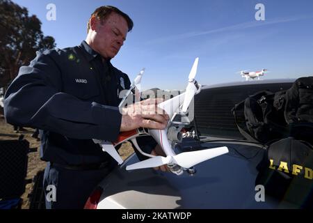 Un pompier et un pilote de drone à distance, Derrick Ward, inspecte un drone lors d'une démonstration médiatique par le service des incendies de Los Angeles à Los Angeles, en Californie, sur 14 décembre 2017. Le LAFD a déployé pour la première fois les drones Phantom 4 Pro et Matrice 100 de DJI pendant le feu de forêt de Skirball.(photo de Ronen Tivony/NurPhoto) Banque D'Images