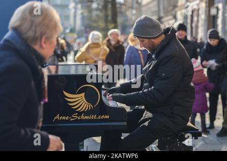 Arne Schmitt, pianiste allemand et musicien de rue, se produit sur la place principale de Cracovie. À l'âge de 29 ans, Arne Schmitt a abandonné son emploi dans un atelier de réparation automobile et a ensuite joué à plein temps dans la rue. Depuis 1997, il voyage - d'abord à temps partiel - avec un piano à travers l'Europe et a déjà joué dans plus de 300 villes. Dimanche, 10 décembre 2017, à Cracovie, en Pologne. (Photo par Artur Widak/NurPhoto) Banque D'Images