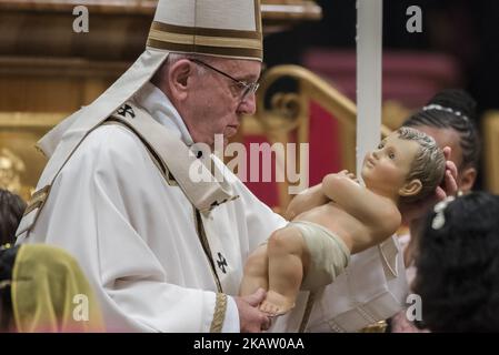 Le pape François tient une statue de bébé Jésus à la fin de la messe de la veille de Noël dans la basilique Saint-Pierre au Vatican, le dimanche 24 décembre 2017. (Photo de Massimo Valicchia/NurPhoto) Banque D'Images