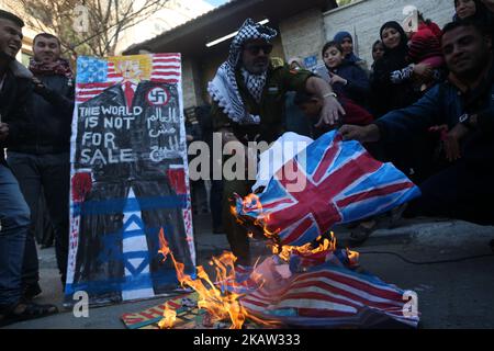 Les Palestiniens brûlent un drapeau israélien et un drapeau américain lors d'une manifestation pour manifester leur solidarité avec les prisonniers palestiniens détenus dans les prisons israéliennes, devant le bureau de la Croix-Rouge à Gaza, sur 8 janvier 2018. (Photo de Majdi Fathi/NurPhoto) Banque D'Images