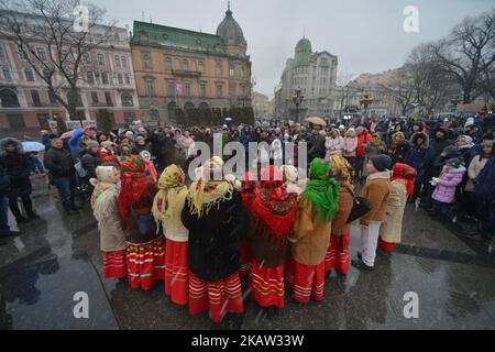 Un groupe de jeunes Carolers de Noël se produisent à la fin de la parade des étoiles de Noël qui a eu lieu à Lviv le deuxième jour de Noël et qui s'exécute de la place Rynok et termine l'avenue Svobody en face de l'Opéra. Faire des étoiles de Noël est une vieille tradition en Ukraine. Le porte-étoile (zvizdar) est la personne qui dirige la vertèbre et tient fièrement l'étoile de Noël à la main brillante sur un long piquet. Faire de la plus belle et lumineuse star de Noël s'est transformé en une vraie compétition dans l'Ukraine occidentale au cours des dernières années. Des centaines de participants de différentes zones et de leur beauté Banque D'Images