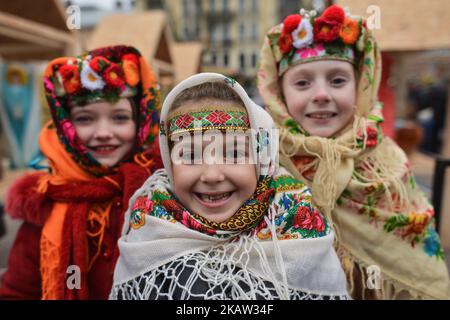 Trois jeunes filles portent des robes folkloriques traditionnelles de différentes régions pendant la parade des étoiles de Noël qui ont lieu à Lviv le deuxième jour de Noël et courent de la place Rynok et termine l'avenue Svobody en face de l'Opéra. Faire des étoiles de Noël est une vieille tradition en Ukraine. Le porte-étoile (zvizdar) est la personne qui dirige la vertèbre et tient fièrement l'étoile de Noël à la main brillante sur un long piquet. Faire de la plus belle et lumineuse star de Noël s'est transformé en une vraie compétition dans l'Ukraine occidentale au cours des dernières années. Des centaines de participants de différents sont Banque D'Images