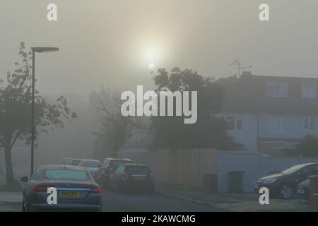 Lever du soleil à travers le brouillard automnal tôt le matin au-dessus des maisons de banlieue à Shepperton Surrey Angleterre Royaume-Uni Banque D'Images