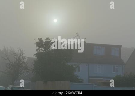 Lever du soleil à travers le brouillard automnal tôt le matin au-dessus des maisons de banlieue à Shepperton Surrey Angleterre Royaume-Uni Banque D'Images