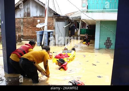 Les agents de secours communs du service des incendies, de la police et de l'Agence régionale d'atténuation des catastrophes de Jakarta ont évacué des résidents alors que des inondations ont frappé plusieurs zones de Jakarta mardi, à 6 février 2018. De fortes pluies qui se sont produites au cours des derniers jours, ont causé un certain nombre de zones de la capitale inondées avec des plages d'eau à haute altitude de 50-200 cm. (Photo par Aditya Irawan/NurPhoto) Banque D'Images