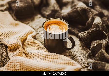 Un mug noir avec café chaud et cannelle fait partie des pulls en laine chaude de différentes couleurs. Une boisson chaude et des vêtements chauds en saison froide. Winte Banque D'Images