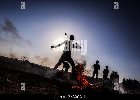 Un manifestant palestinien lance des pierres vers des soldats israéliens lors d'une manifestation près de la frontière de la bande de Gaza avec Israël, dans l'est de la ville de Gaza, samedi, 31 mars 2018 (photo de Mamen Faiz/NurPhoto) Banque D'Images