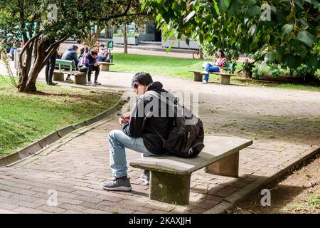 Bogota Colombie,El Chico Carrera 11 Parque ChicÃ³ Reservado II Park, homme hommes homme banc de repos, smartphone mobile téléphone portable utilisant la lecture de SMS échec Banque D'Images