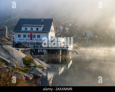 Lever de soleil le matin d'une brumeuse, le col de montagne de l'hôtel Grimsel au lac Totensee, en Suisse. Banque D'Images