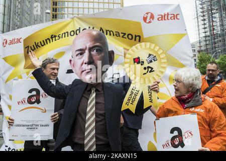 Un activiste vêtu du PDG d'Amazon Jeff Bezos est photographié lors d'une manifestation à laquelle ont assisté des travailleurs d'Amazon, des membres de syndicats et qui ont quitté leurs activités sous la devise « Make Amazon Pay » à Berlin, en Allemagne, sur 24 avril 2018. Jeff Bezos, fondateur d'Amazon, recevra aujourd'hui le prix Axel-Springer 2018 au siège d'Axel-Springer à Berlin Kreuzberg pour son esprit d'entreprise visionnaire. Les manifestants, originaires de différents pays comme la Pologne et l'Espagne, se plaignent et protestent contre l'exploitation du travail et les mauvaises conditions de travail dans l'entreprise. (Photo par Emmanuele Contini/NurPhoto) Banque D'Images