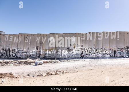 Une femme palestinienne marche à côté d'un mur de sécurité concret construit par Israël pour séparer les Palestiniens d'Israël à Qalandia, Palestine sur 9 juin 2018. Les Palestiniens disent que le mur est illégal et les sépare des autres territoires occupés de Jérusalem-est. (Photo par Dominika Zarzycka/NurPhoto) Banque D'Images