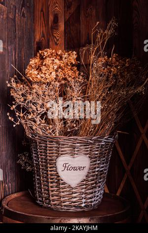 Fleurs séchées dans un panier en osier. Décoration intérieure naturelle Banque D'Images