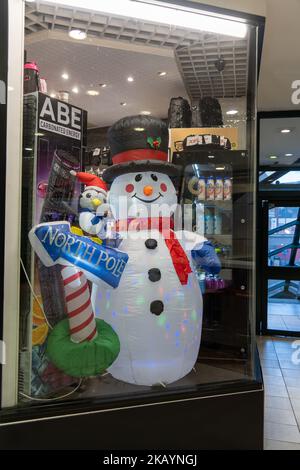 Un bonhomme de neige gonflable dans une fenêtre de magasin, alors que le détail se prépare pour Noël à Newcastle upon Tyne, Royaume-Uni. Banque D'Images