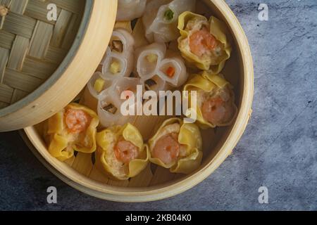 Mélange dim sum cuit à la vapeur dans un panier en bois de bambou.large gamme de petits plats chinois qui sont traditionnellement appréciés dans les restaurants pour le brunch Banque D'Images