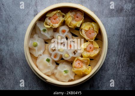 Mélange dim sum cuit à la vapeur dans un panier en bois de bambou.large gamme de petits plats chinois qui sont traditionnellement appréciés dans les restaurants pour le brunch Banque D'Images