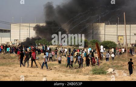 Une photo prise sur 20 juillet 2018 montre des bidons de gaz lacrymogènes tirés par les forces israéliennes qui atterrissent au milieu des manifestants. Des avions et des chars israéliens ont frappé des cibles à travers la bande de Gaza sur 20 juillet après avoir tiré des coups de feu sur des troupes à la frontière, l'armée israélienne a déclaré dans une déclaration sans ajouter si des soldats avaient été blessés dans les tirs. (Photo de Majdi Fathi/NurPhoto) Banque D'Images