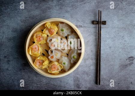 Mélange dim sum cuit à la vapeur dans un panier en bois de bambou.large gamme de petits plats chinois qui sont traditionnellement appréciés dans les restaurants pour le brunch Banque D'Images