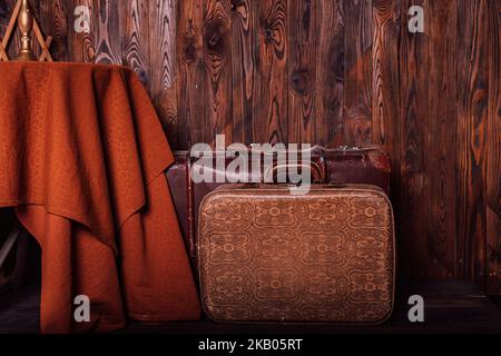 Vieilles valises d'époque près d'une table près d'un mur en bois brun. Style rétro Banque D'Images