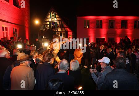 Bavière, Nördlingen: 03 novembre 2022, les gens entourent une statue de l'ancien buteur de but Gerd Müller, après son dévoilement. Le footballeur Gerd Müller, décédé à l'été 2021, sera à l'avenir vu avec son but de coupe du monde de 1974 sur un monument en bronze dans la ville où est né le buteur de but. Dans la ville souabe de Nördlingen, une sculpture a été dévoilée jeudi soir, montrant Gerd Müller marquant le 2-1 contre les pays-Bas lors de la finale au stade olympique de Munich. Photo : Karl-Josef Hildenbrand/dpa Banque D'Images